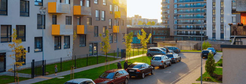 exterior view of an apartment building with side street guest parking in view