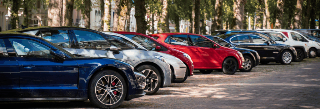 cars parked side by side angled under neighborhood trees