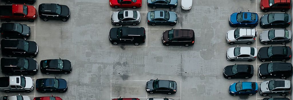 various vehicles, mainly vans parked in an open lot Online Parking Permits for Apartments